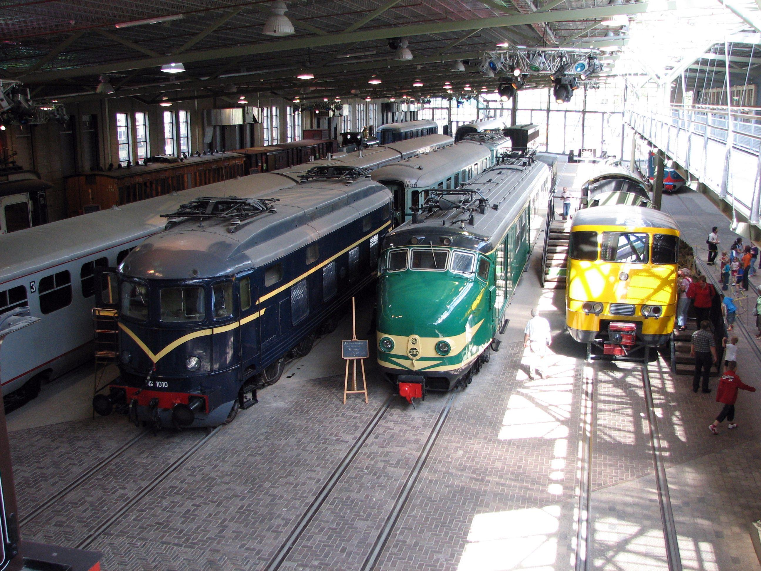 Locomotive série 1000 en livrée bleu nuit à côté d'une rame Mat'54 dite Hondekop en livrée verte, à droite le mock-up de l'avant d'une automotrice Sprinter.

A class 1000 Locomotive in night blue livery next to a green Mat'54 EMU called Hondekop and to the right, the mock-up of the front end of a Sprinter EMU.