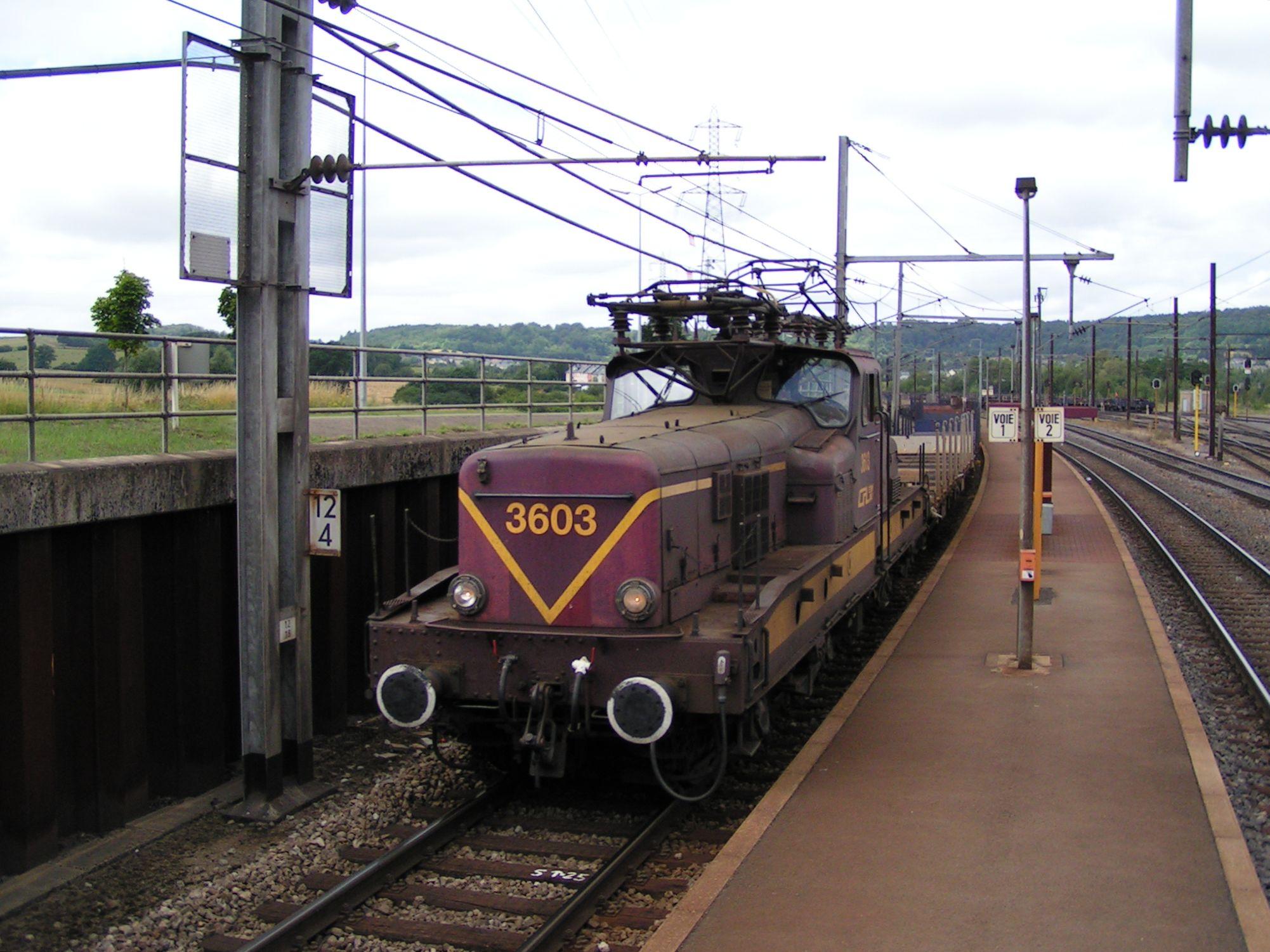 Une locomotive série 3600 en tête d'un train de marchandises traverse l'arrêt de Belval-Usines. 

A locomotive class 3600 heading a freight train through the stopping place of Belval-Usines.