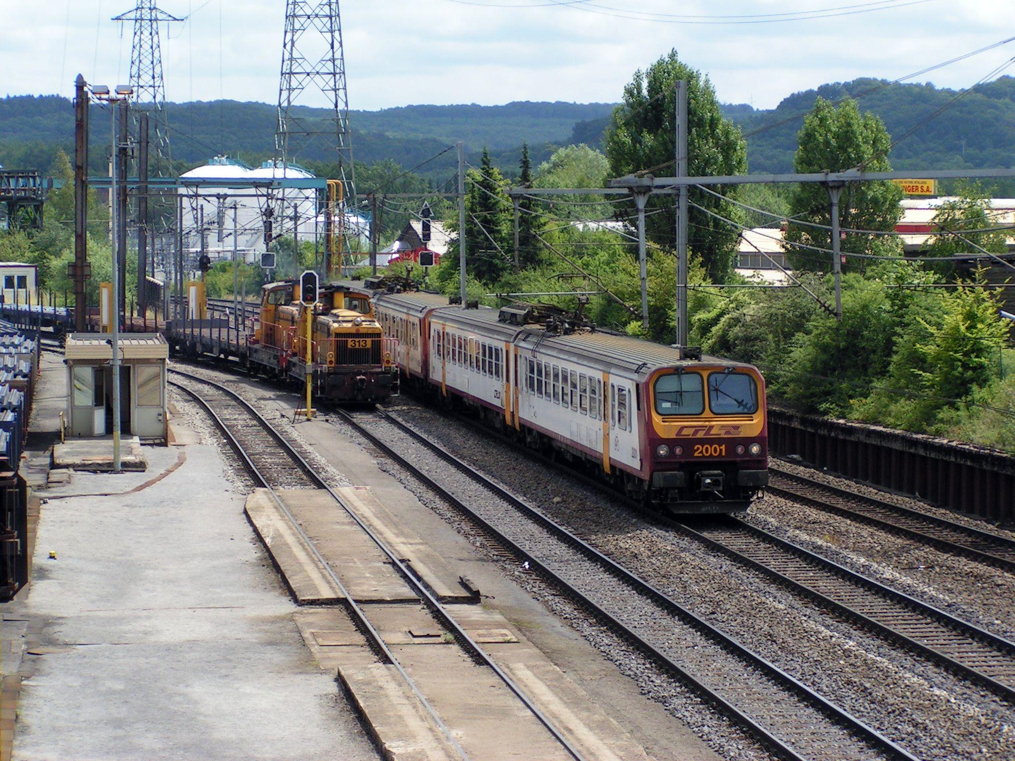 Tandis qu'une automotrice Z 2000 des CFL arrive à Belval-Usines. Un locotracteur de ARBED manoeuvre des wagons.

A EMU Class Z 2000 is arriving in Belval-Usines while a shunter of the ARBED is shunting freight wagons.
