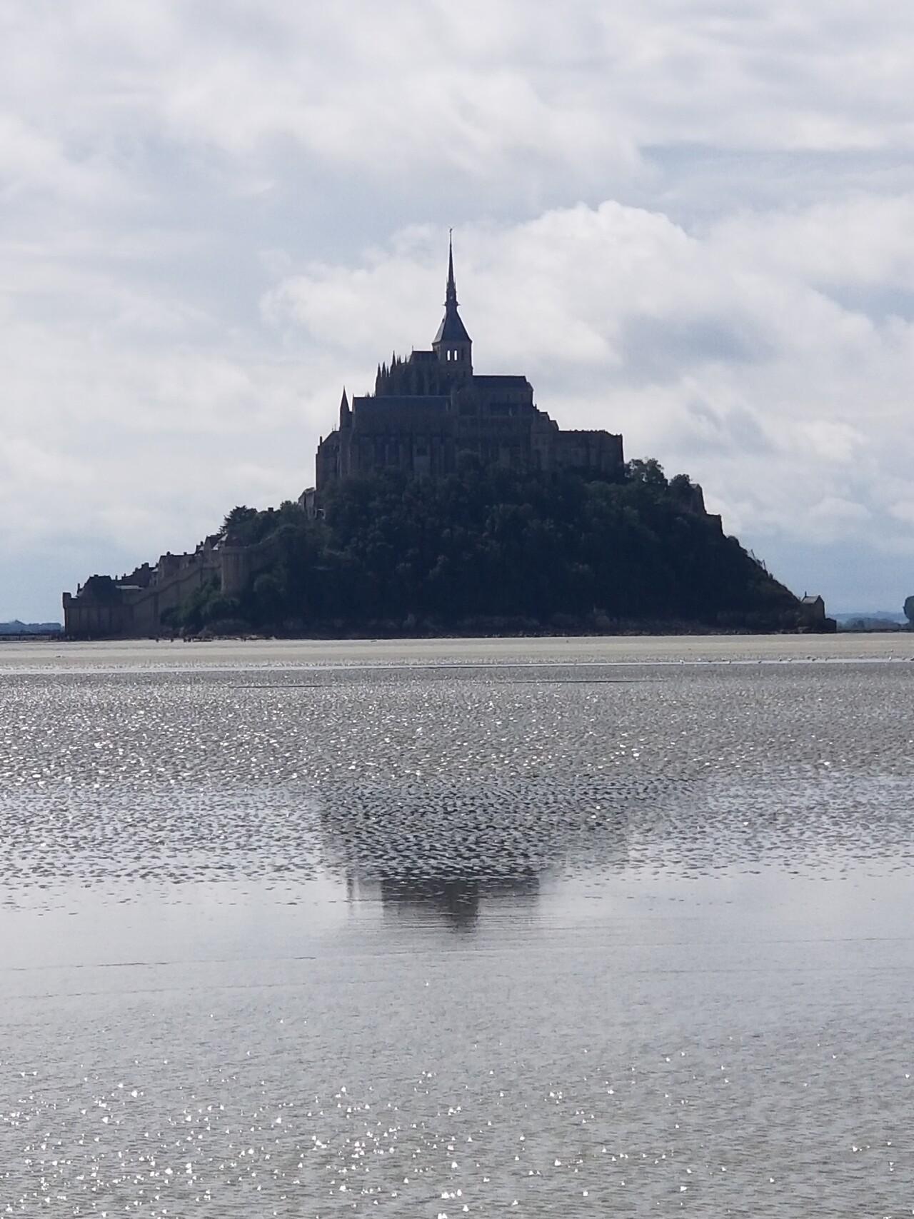 Le Mont-Saint-Michel en Normandie, se reflétant dans la mer.