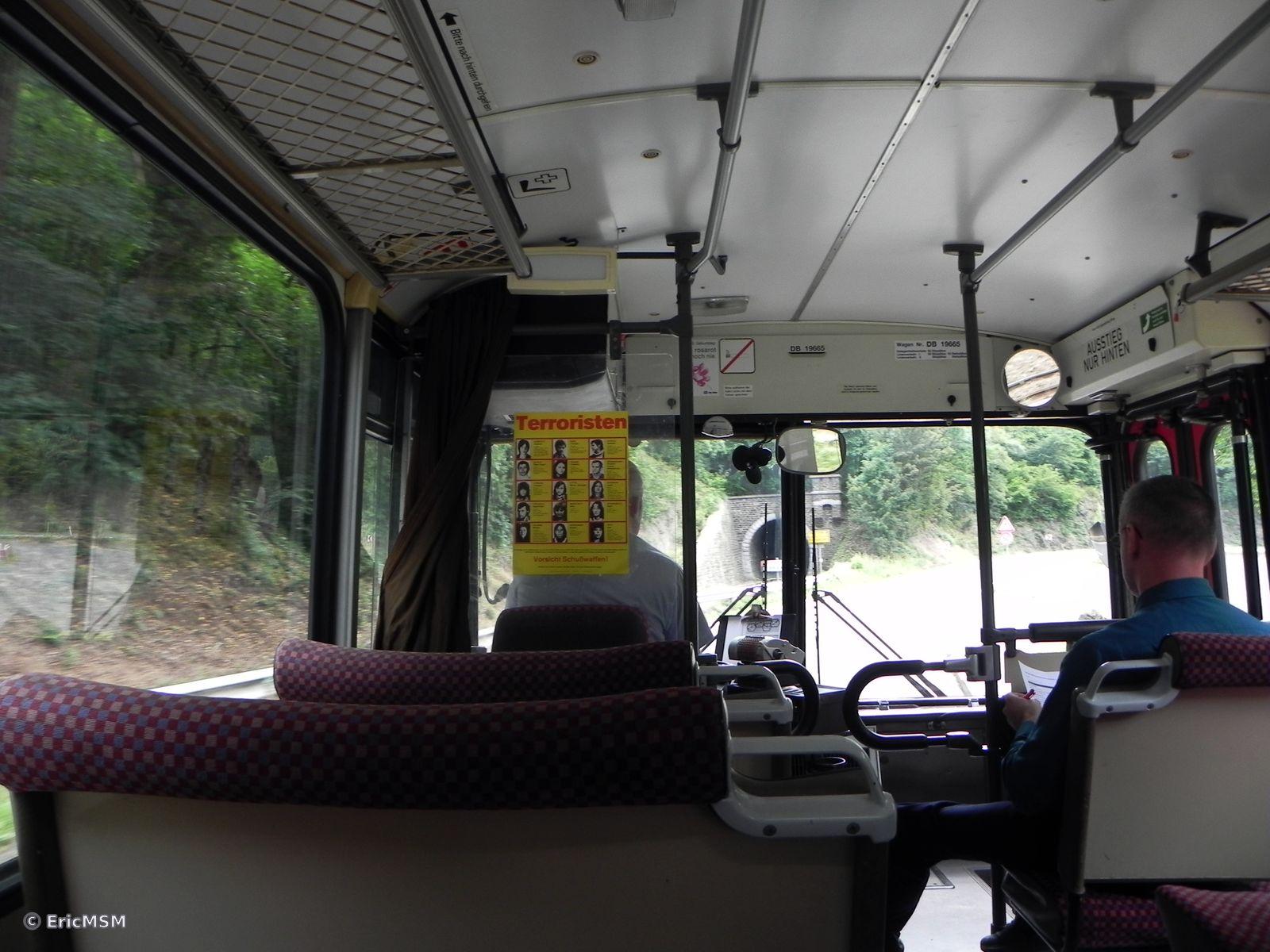 Intérieur d'un ancien autobus en regardant vers l'avant du véhicule. On remarquera une affiche des années 1980 concernant la recherche de terroristes.
Interior of an old bus looking towards the front of the vehicle. Note a poster from the 1980s concerning the search for terrorists.