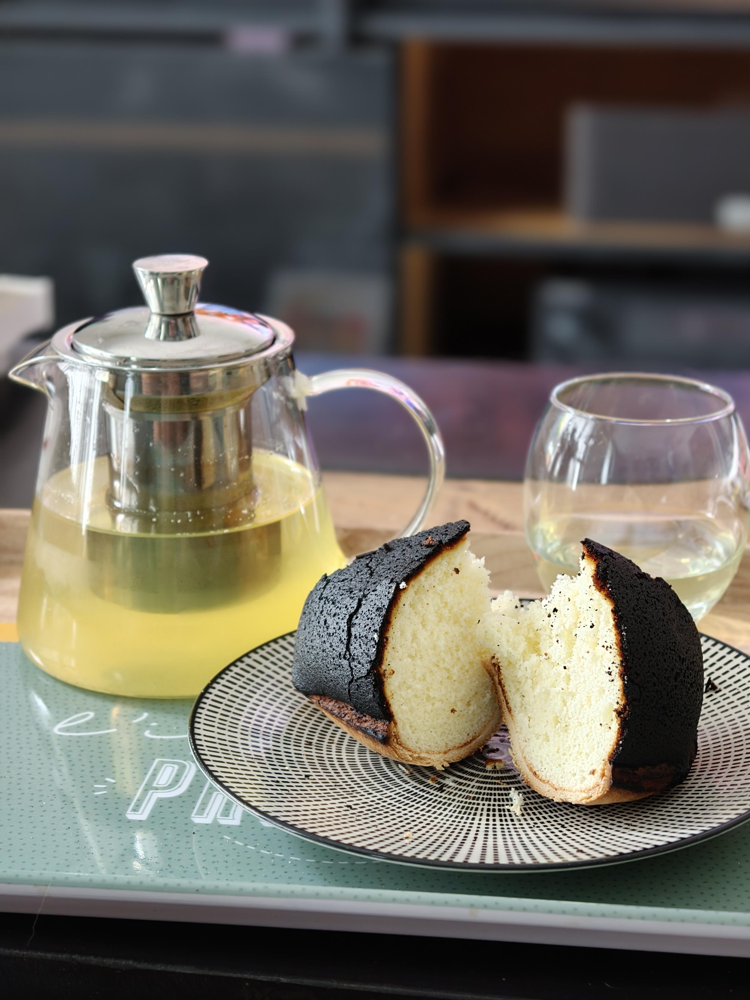 Théière, verre avec du thé vert parfumé et une assiette avec deux parts de gâteau au fromage