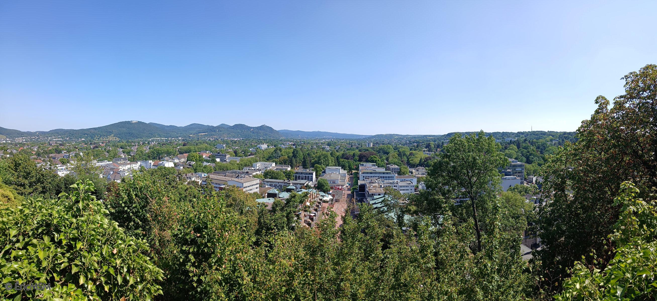 Panorama sur la ville de Bonn-Bad Godesberg, dans le fond, on aperçoit les Siebengebirge, sept pointes qui se détachent du paysage, à gauche, le Petersberg avec son imposant hôtel blanc, et plus loin, la dernière pointe, c'est le Drachenfels avec les ruines du château au sommet. 

Panorama of the city of Bonn-Bad Godesberg, in the background, we can see the Siebengebirge, seven points which stand out from the landscape, on the left, the Petersberg with its imposing white hotel, and further on, the last point is the Drachenfels with the castle ruins at the top.