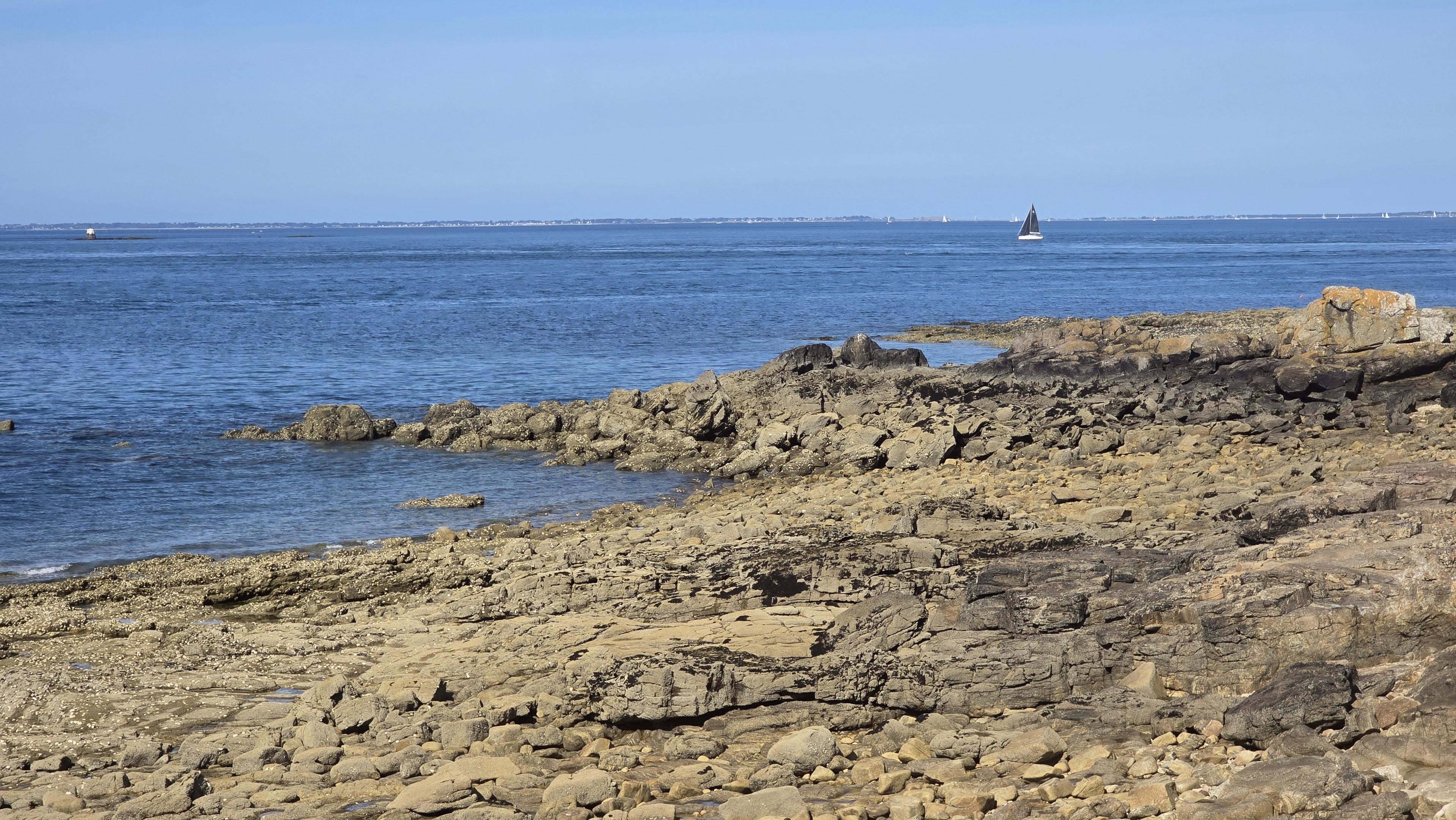 Voiliers et côte rocheuse, en regardant vers le sud, on distingue Belle-Île au loin.